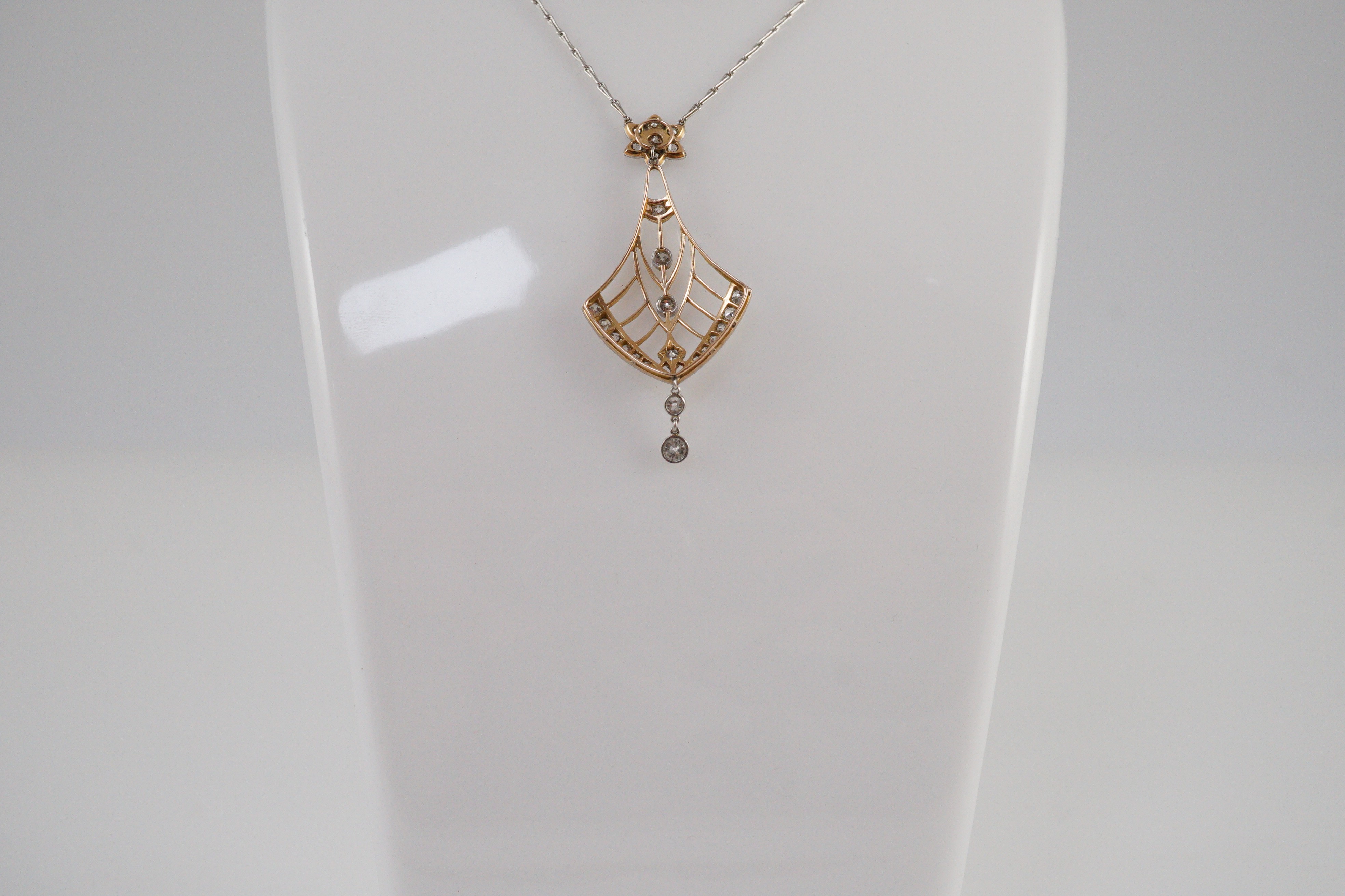 An early to mid 20th century pierced platinum, gold and millegrain set diamond cluster drop pendant
